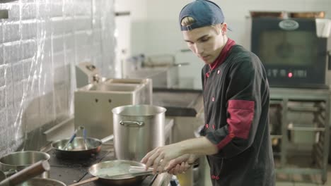 chef preparando ensalada césar en una cocina profesional