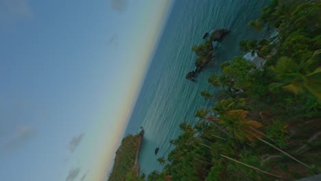 Vertical-Dynamic-fpv-flight-over-tropical-Punta-Balandra-with-beautiful-beach-and-rocky-island-in-Caribbean-Sea-at-golden-sunset