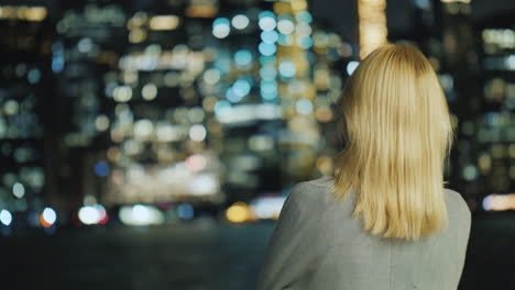 Mujer-Rubia-Mirando-La-Vista-Trasera-De-La-Ciudad-De-Noche