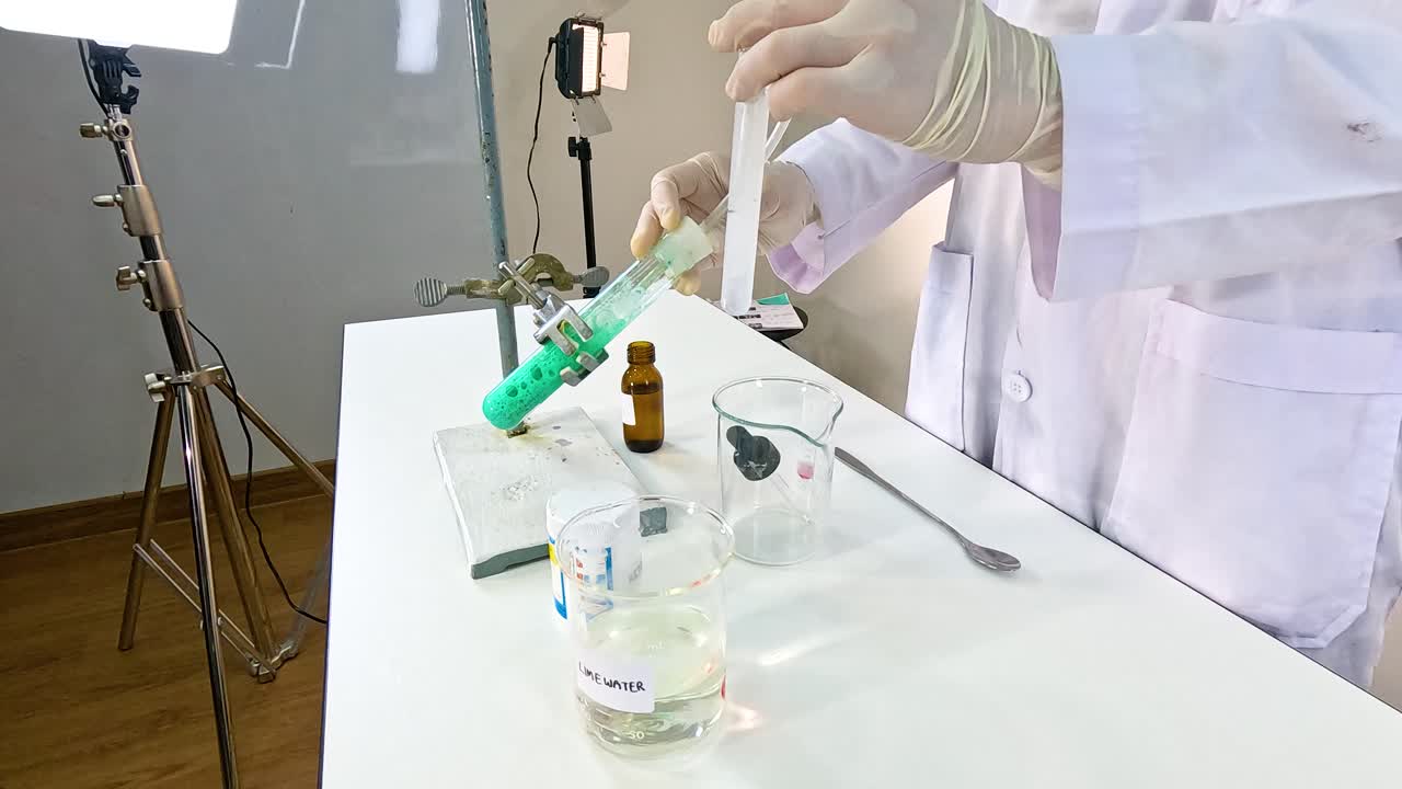A scientist conducts a chemical reaction between copper carbonate and sulfuric acid in a controlled laboratory setting
