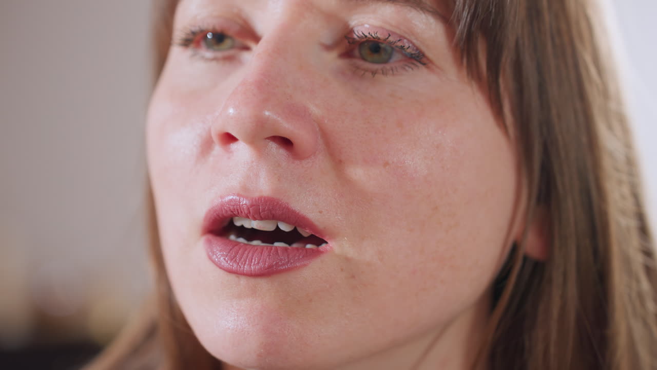 Close up of therapeutic companion speaking softly with empathy, showcasing facial expression and lip movement as she engages in client support during session in calm, inviting environment