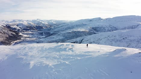 Persona-En-órbita-Aérea-Esquiando-En-La-Cima-De-Una-Montaña-Nevada-En-Un-Hermoso-Paisaje-Invernal