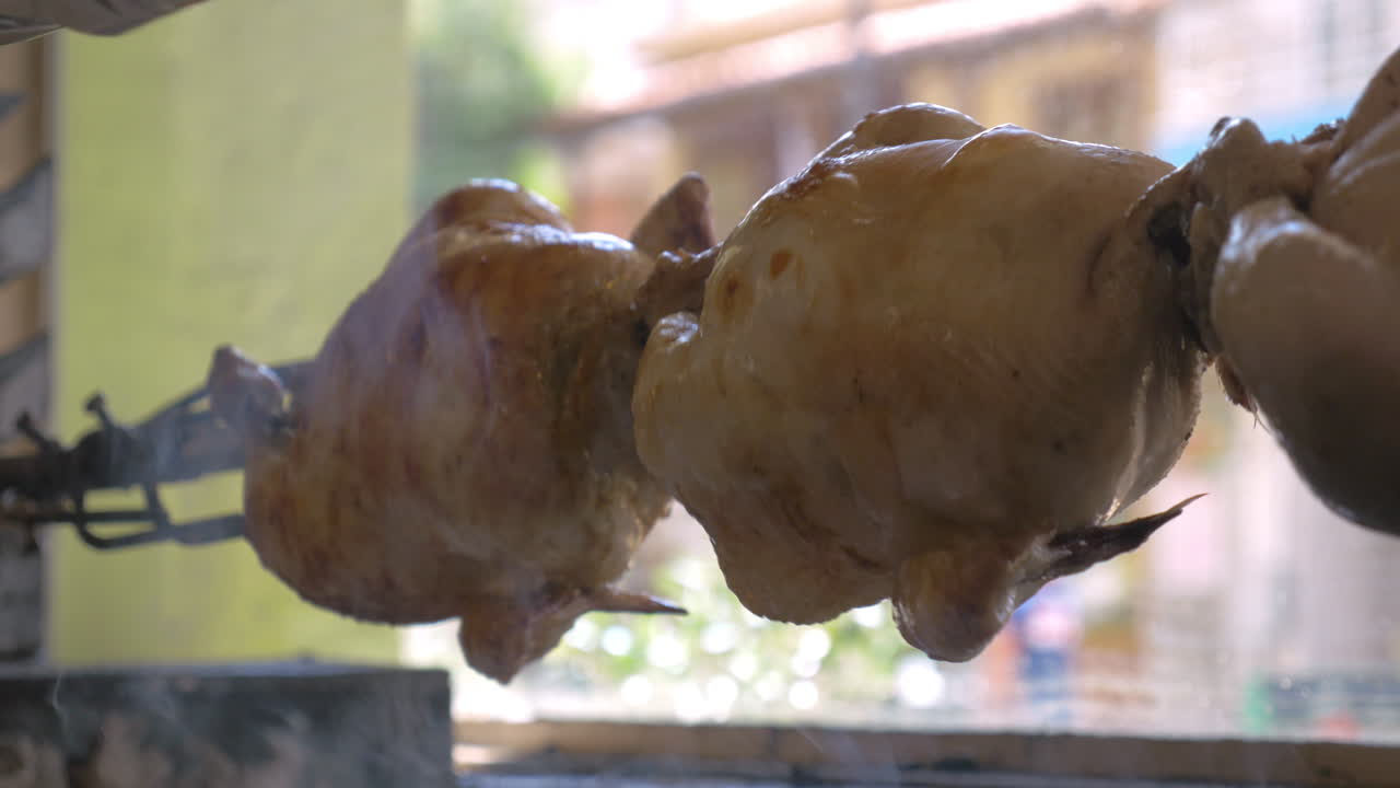 disparo en primer plano de cocinar pollo apetitoso en un escupido con un ligero humo fragante