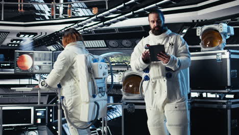 astronaut reading mission plan on tablet before stepping out of space station