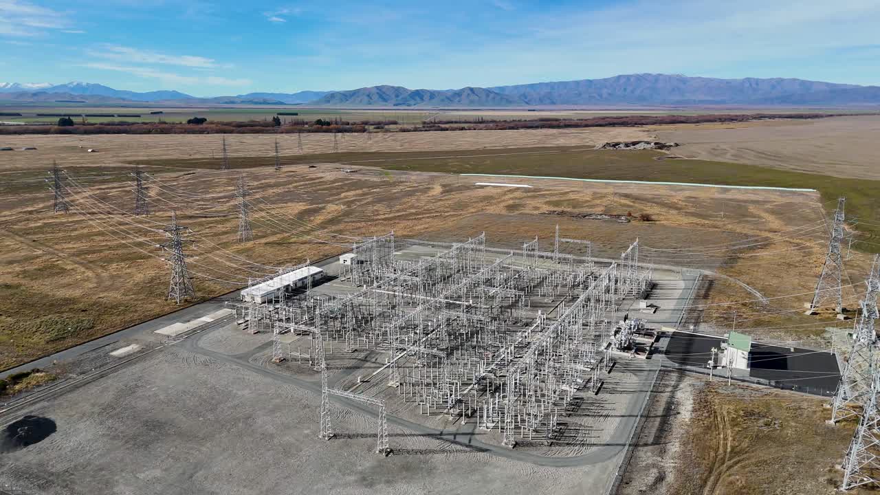 Aerial footage of a power substation at Lake Tekapo, New Zealand, showcasing high-voltage infrastructure against a scenic autumn landscape