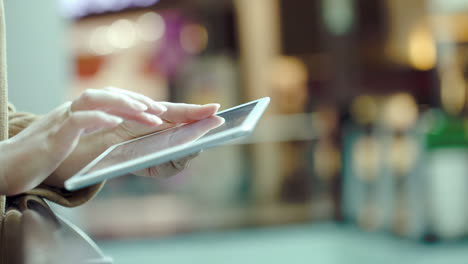 mujer usando una tableta en un lugar público