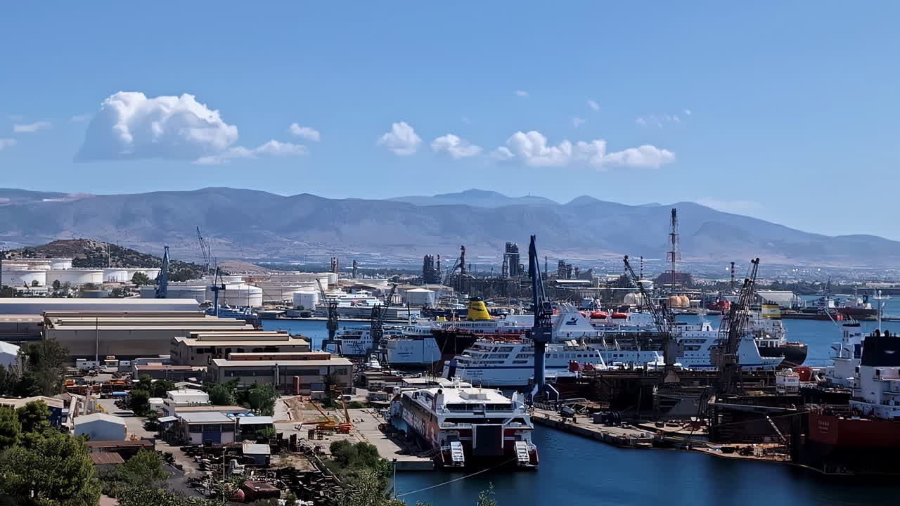 Slow motion landscape of ships ferry docked in harbour waterfront pier jetty in seaside bay coastline with mountain range headland and clouds in sky industry port cargo terminal shipping vessels