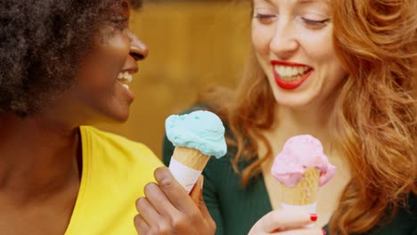 two happy women enjoying colorful ice cream cones