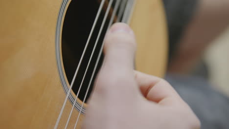 Imágenes-En-Cámara-Lenta-De-Un-Pulgar-Rasgueando-Las-Cuerdas-De-Una-Guitarra