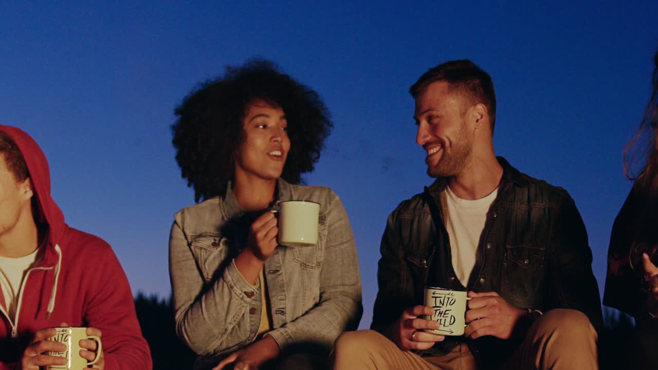 친구 들 이 밤 에 캠프 불 을 즐기고 있다