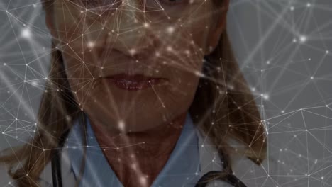 Animation-of-dots-interconnecting-with-lines-over-smiling-female-caucasian-doctor-in-lab-coat