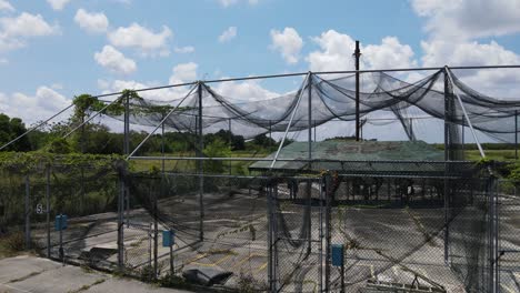 smooth-aerial-left-to-right-view-of-an-abandoned-batting-cage-in-South-Florida