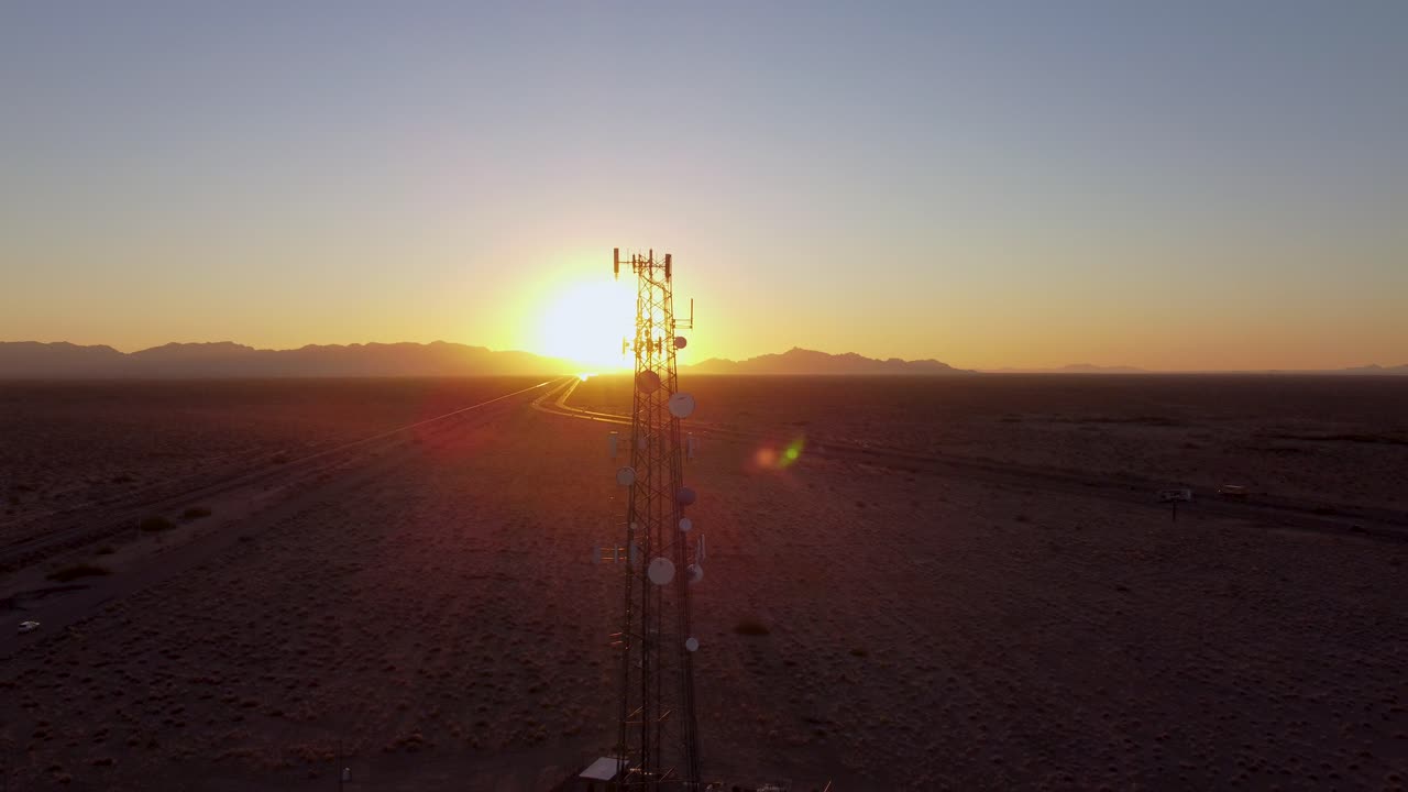 Aerial: Cell phone tower at sunset in Arizona desert. Wide angle.