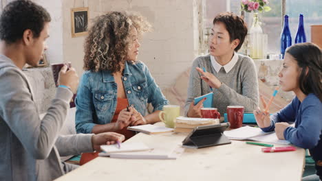 diverse group of students studying at home using books and laptop technology