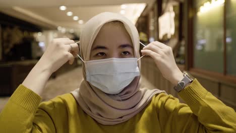 asian muslim women putting on protective face masks as a new-normal protocol