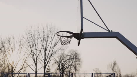 camera focuses on basketball hoop at sunset