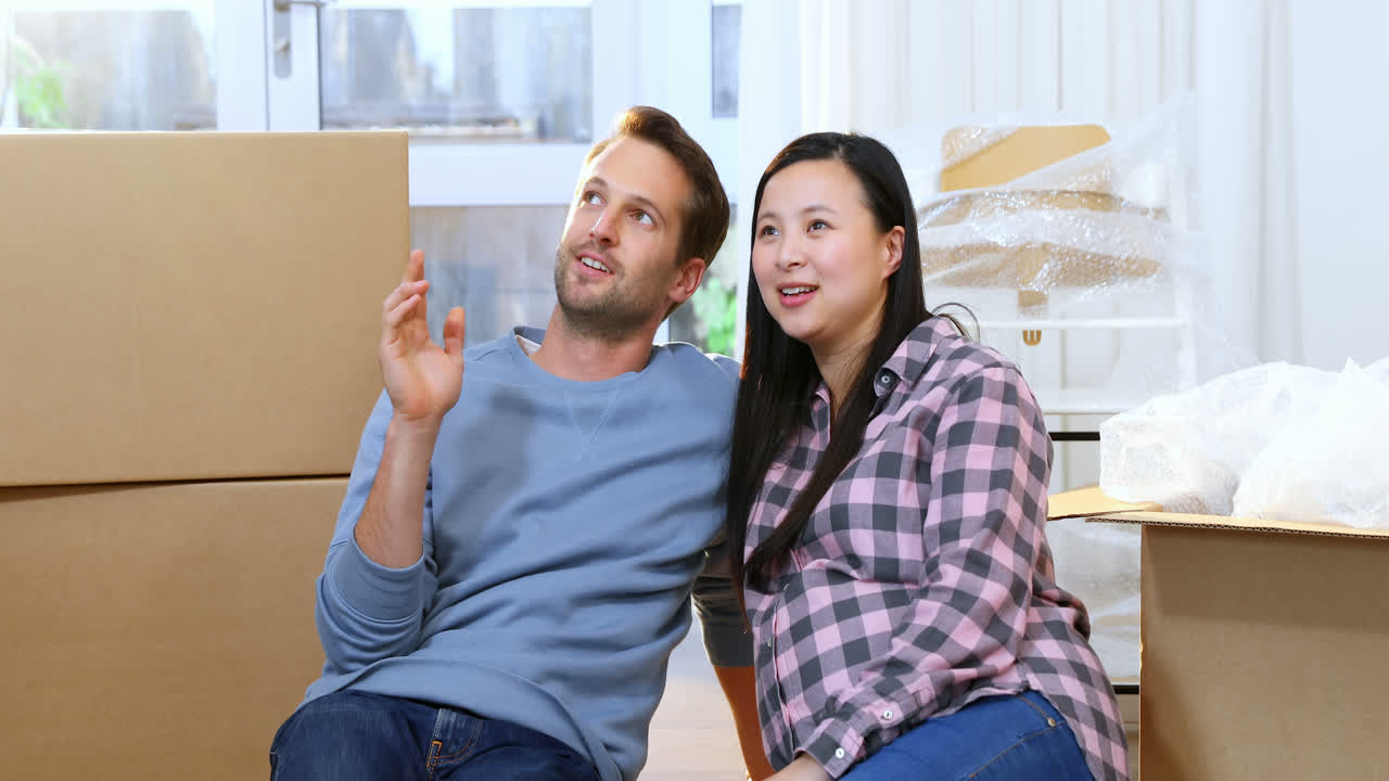 pareja embarazada interactuando entre sí en su nueva casa 4k