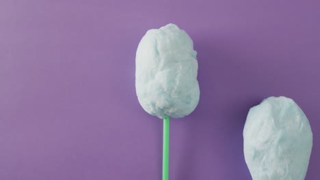 video of marshmallows on sticks lying on purple surface