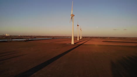 Imponentes-Molinos-De-Viento-En-Campos-Verdes-Contra-El-Cielo-Azul-Al-Atardecer-En-Nueva-Beijerland,-Países-Bajos