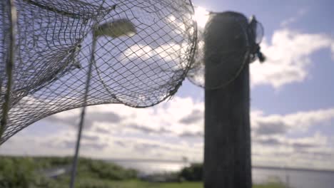 an old fishing net hanging on a pole next to the coast in sweden