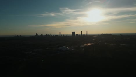 silhouettes of smokestacks and cooling tower of steel factory in galati, romania. wide aerial shot