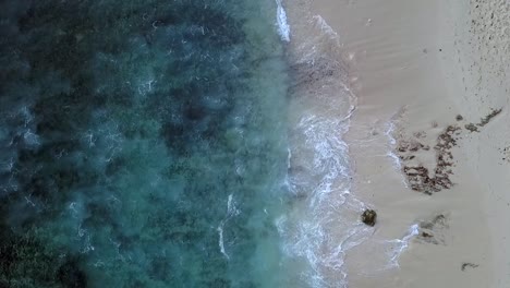 Great-aerial-view-flight-drone-camera-pointing-down-drone-footage-ot-idyllic-dream-beach-with-beachfront-resort-in-Nusa-Lembongan-at-midday-noon-time-in-Bali