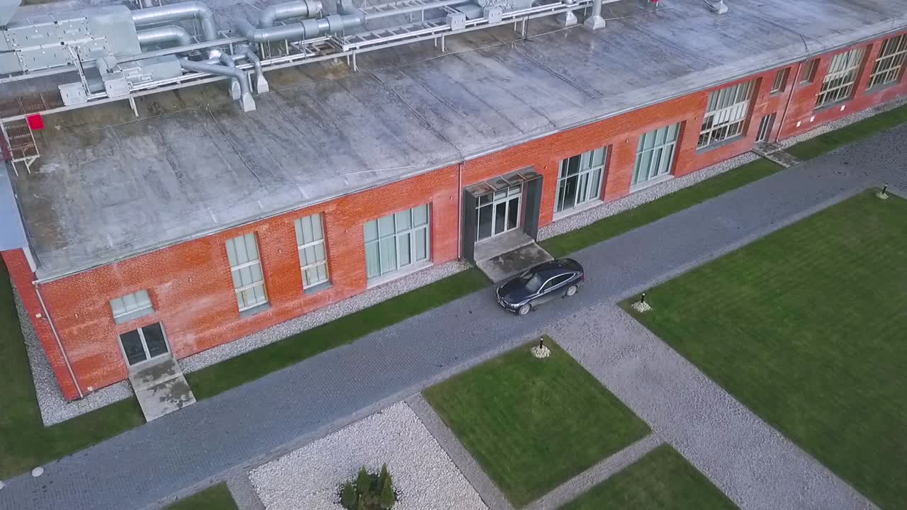 vista aérea del edificio moderno de la fábrica de ladrillos con paisajismo y estacionamiento