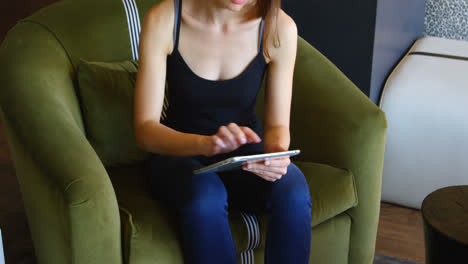 Front-view-of-young-caucasian-businesswoman-working-on-digital-tablet-in-a-modern-office-4k