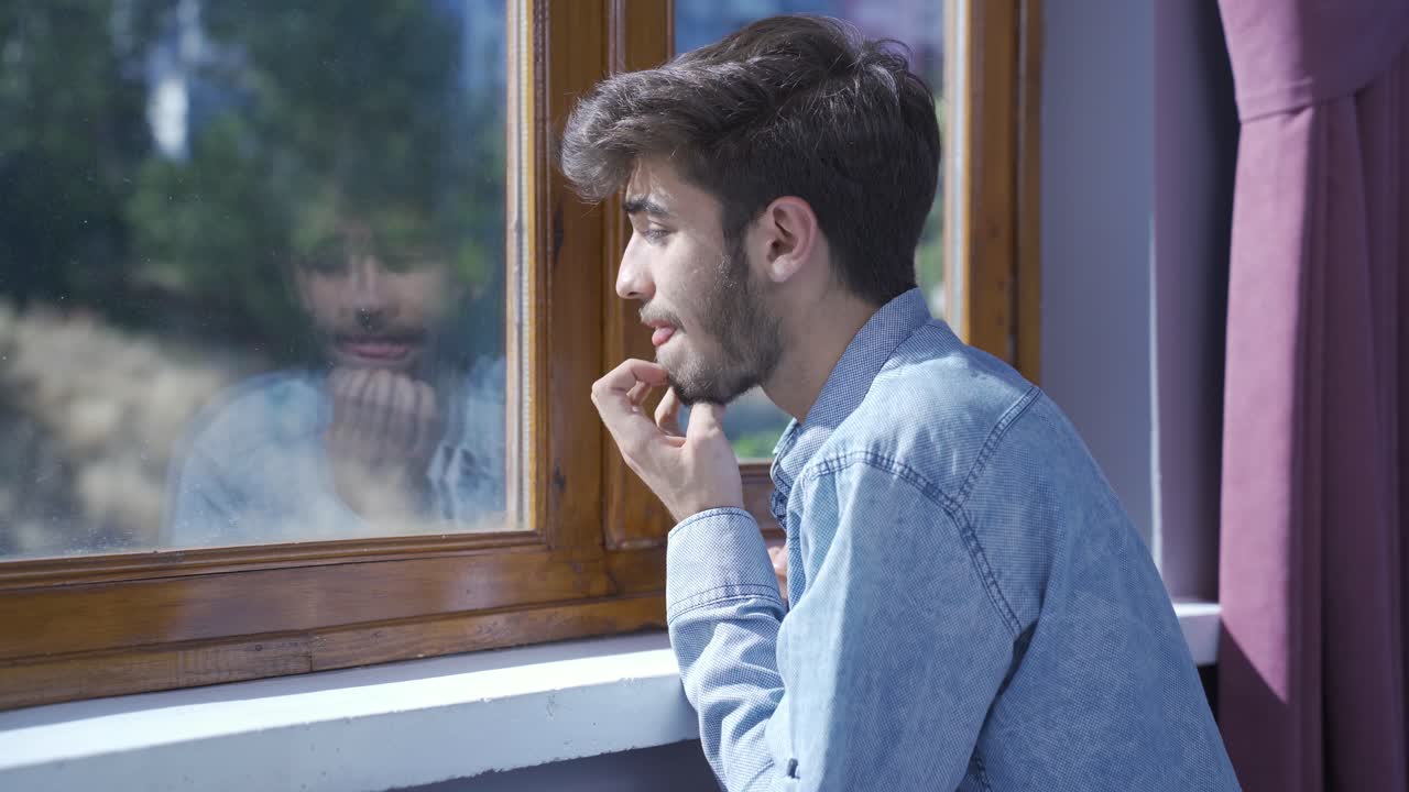 Uomo preoccupato e nervoso a casa che guarda fuori