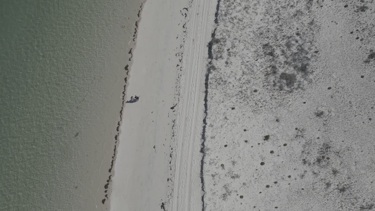 위에서, 낙원 같은 해변은 해안선을 따라  ⁇ 고 로맨틱한 순간을 공유하는 부부가 자주 찾는 곳입니다. 그들의 바 ⁇ 가 탈출의 이 ⁇ 한 아름다움을 포착합니다.