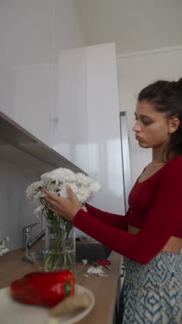 woman arranging flowers in a modern kitchen