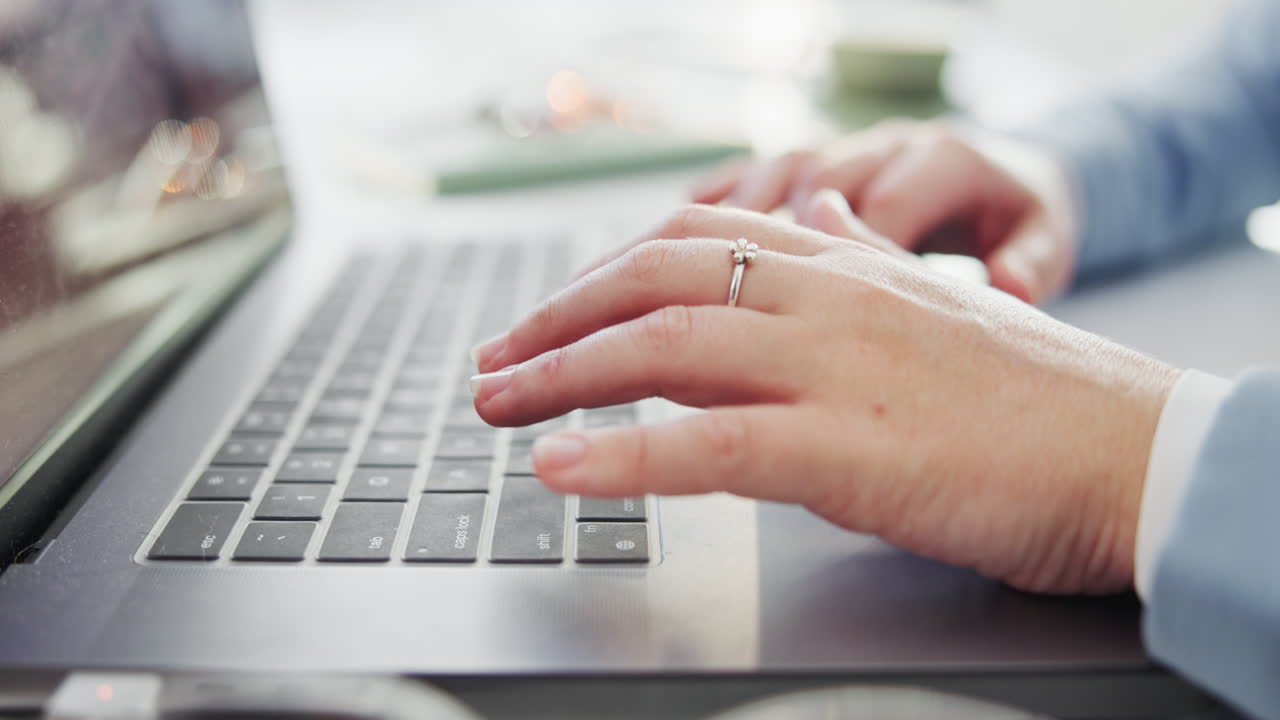 Hands typing on a laptop