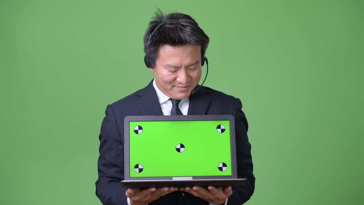 녹색 배경에 성숙한 일본 사업가