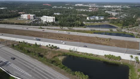 Vista-Aérea-De-La-Autopista-Y-Rampa-Con-Tráfico-A-Un-Centro-Comercial-De-Lujo-Ubicado-En-Sarasota,-Florida