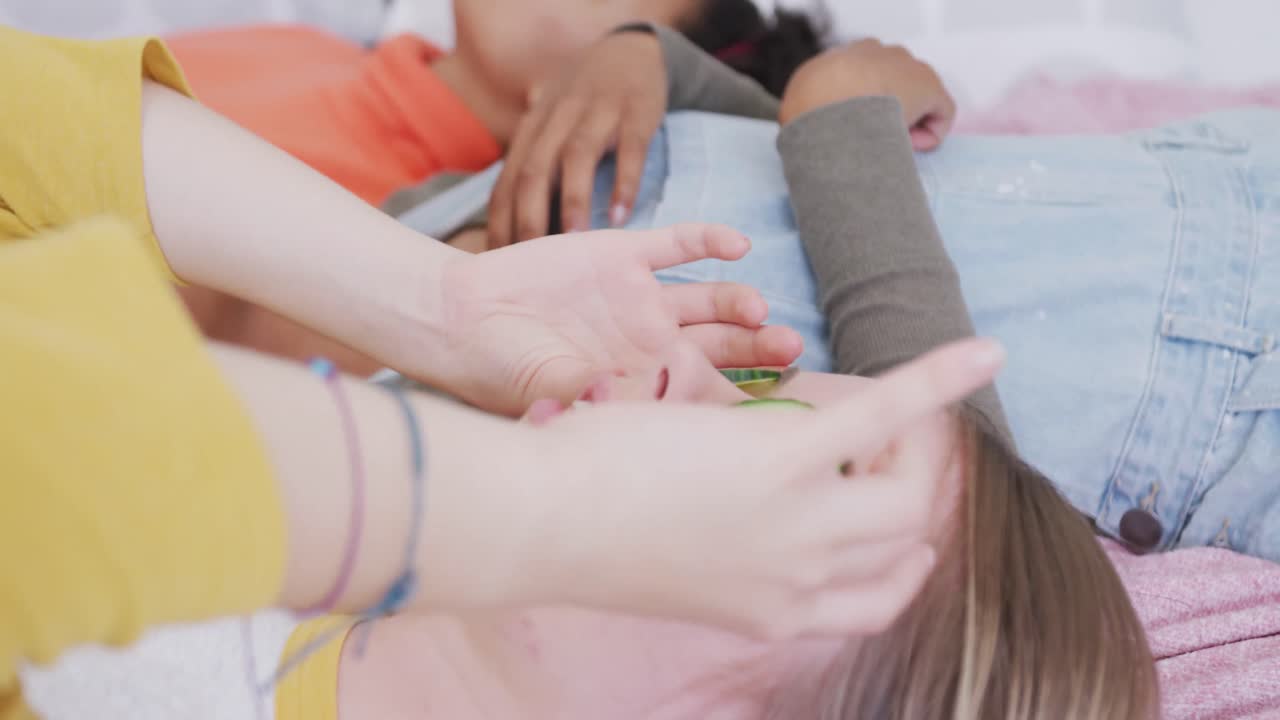 행복한 다양한 십대 소녀 친구들이 침대에 누워 얼굴에 호박 조각, 느린 동작