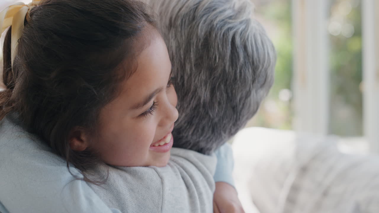 행복한 소녀는 아 ⁇ 으로 할머니를 환영합니다. 할머니는 미소 짓고 손녀를 포옹합니다. 집에서 손녀로부터 아 ⁇ 을 즐기고 있습니다. 가족 개념 4k