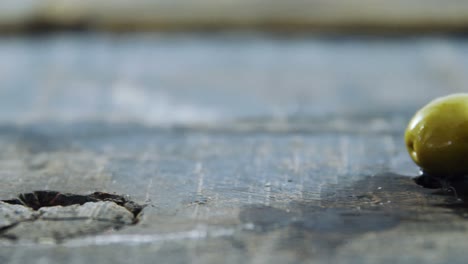 Two-green-olives-on-a-wooden-board