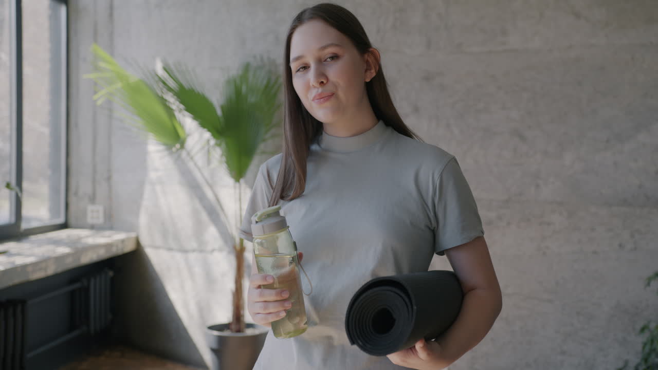 Woman with Yoga Mat and Water Bottle