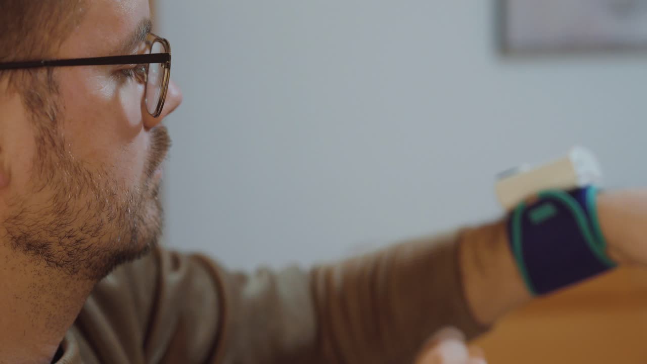 Un uomo misura la propria pressione sanguigna a casa, con il viso visibile. Concetto di auto-cura, monitoraggio della salute domestica, prevenzione e responsabilità personale per la salute