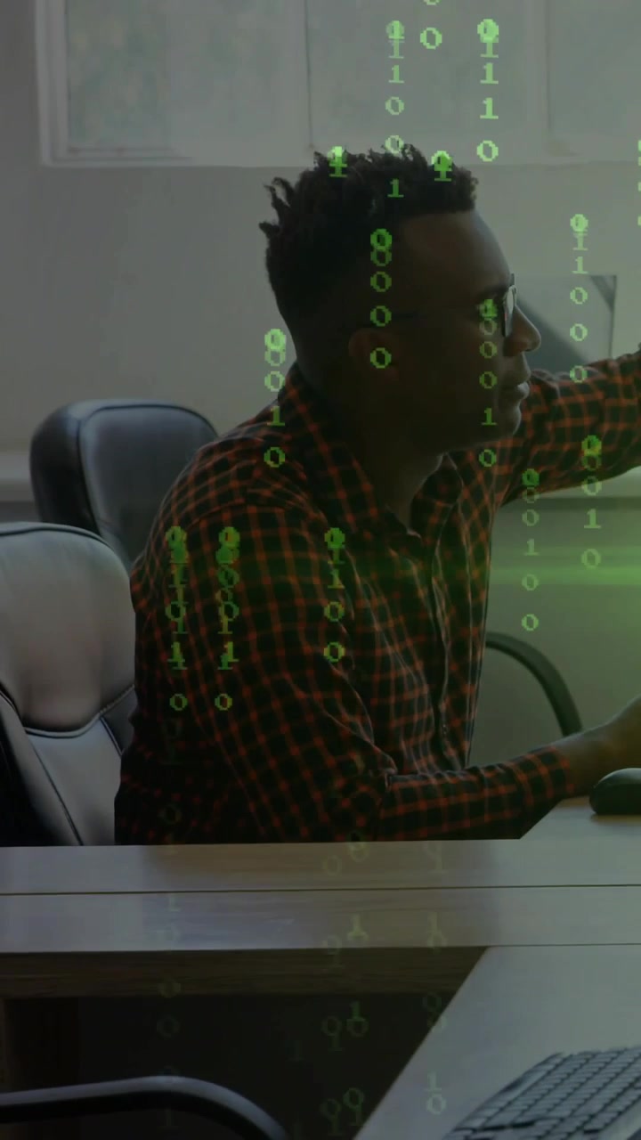 Vertical video: Man seeing tech alert, reaching and typing while green code responding to his reach