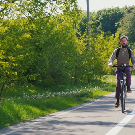 Ein-Mann-Fährt-Fahrrad-Hinter-Sich-Einen-Rucksack-1