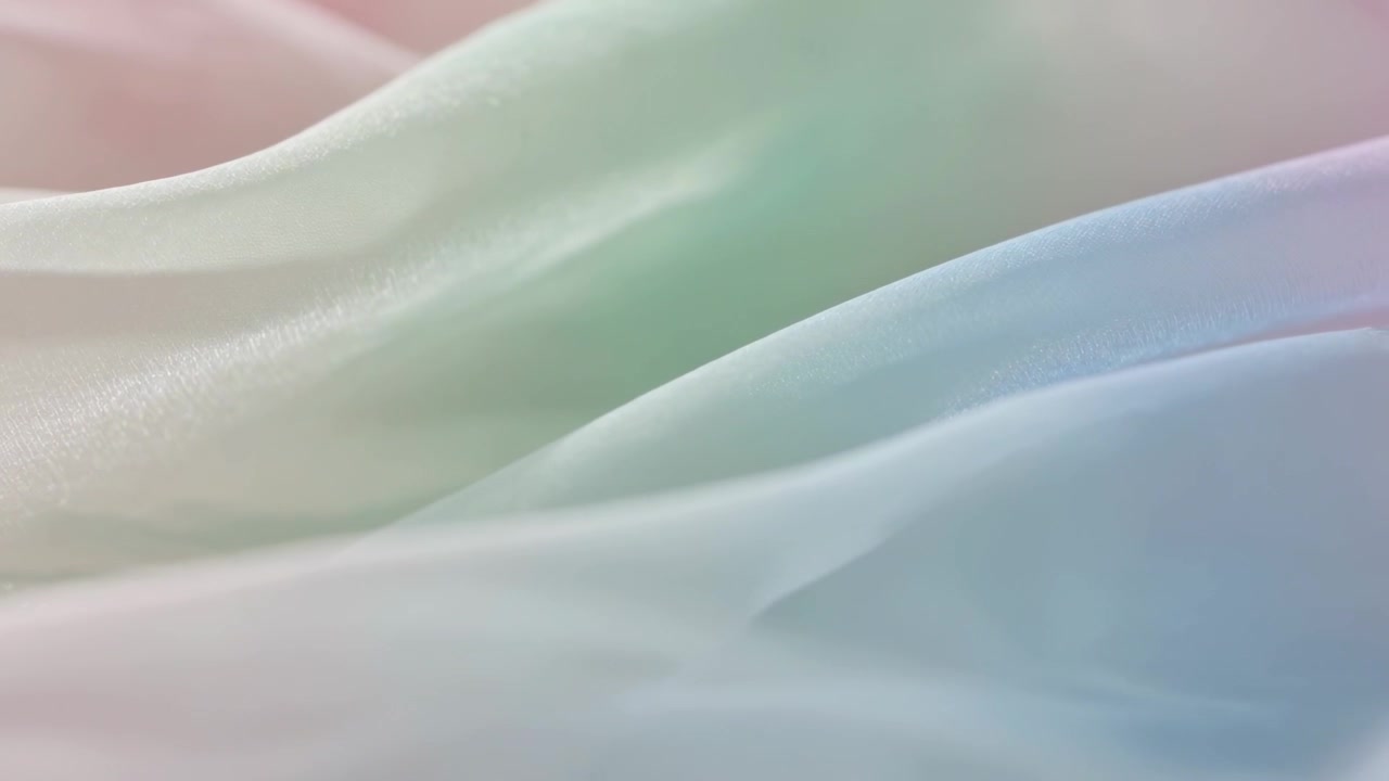 Rippling translucent draped fabric shifting with soft light moving in studio, revealing highlights
