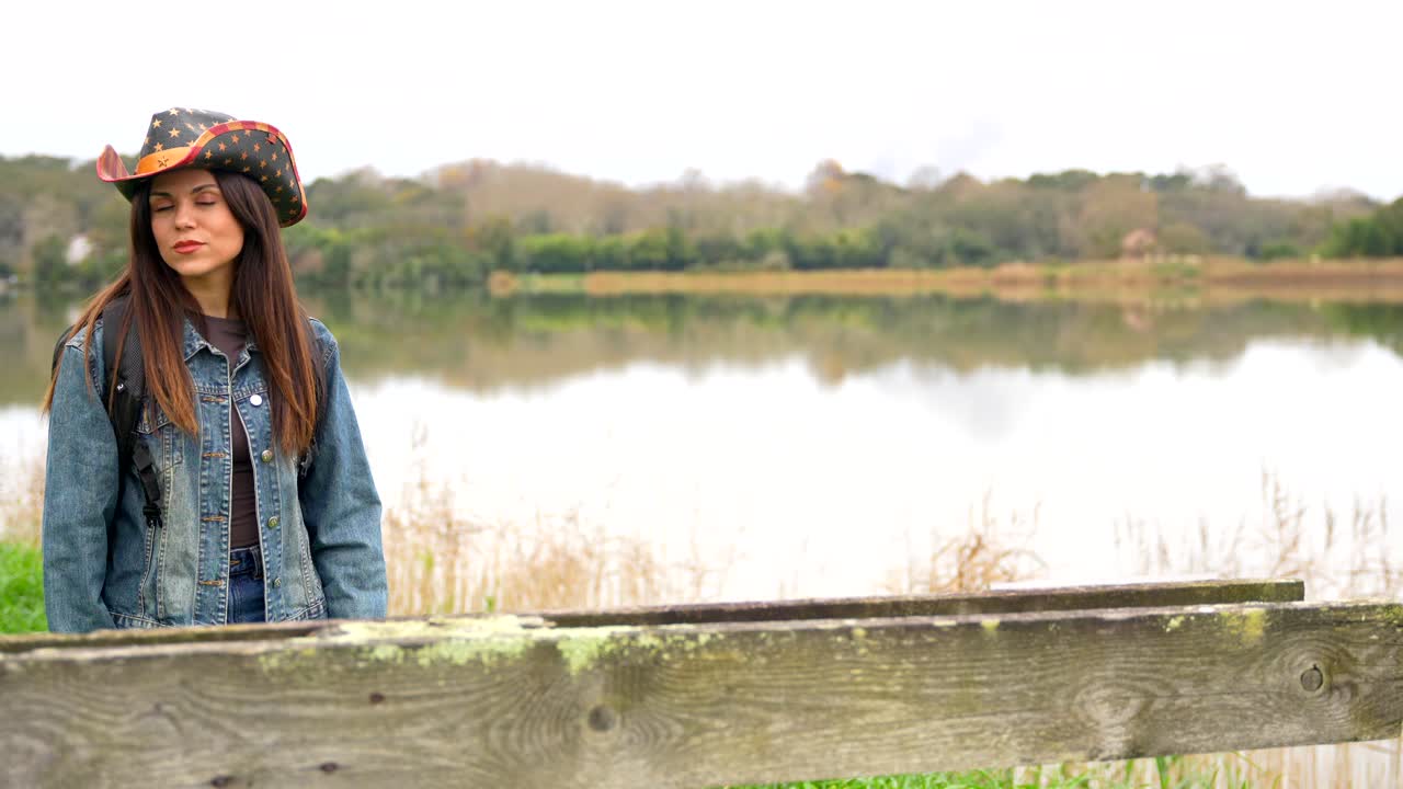 Woman in Cowgirl Hat by the Lake