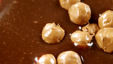 bolas de caramelo en chocolate derretido 4k