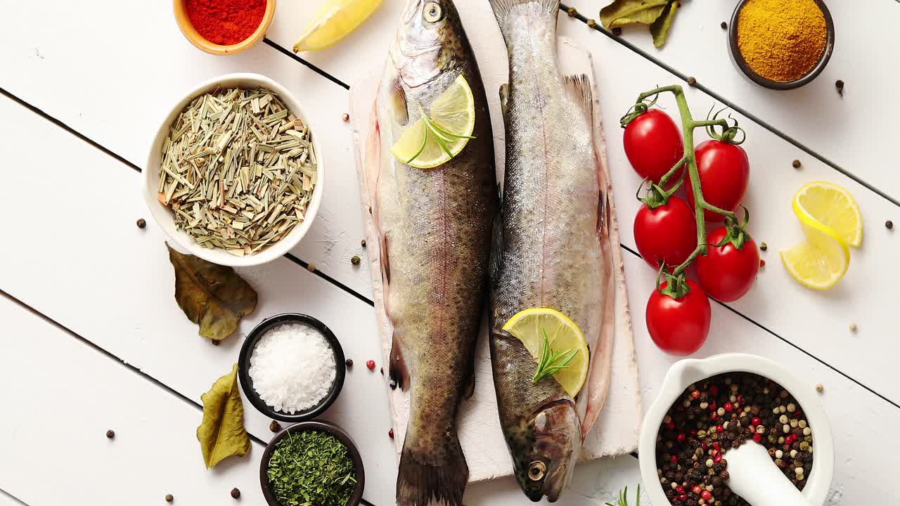 especias aromáticas y verduras alrededor del pescado