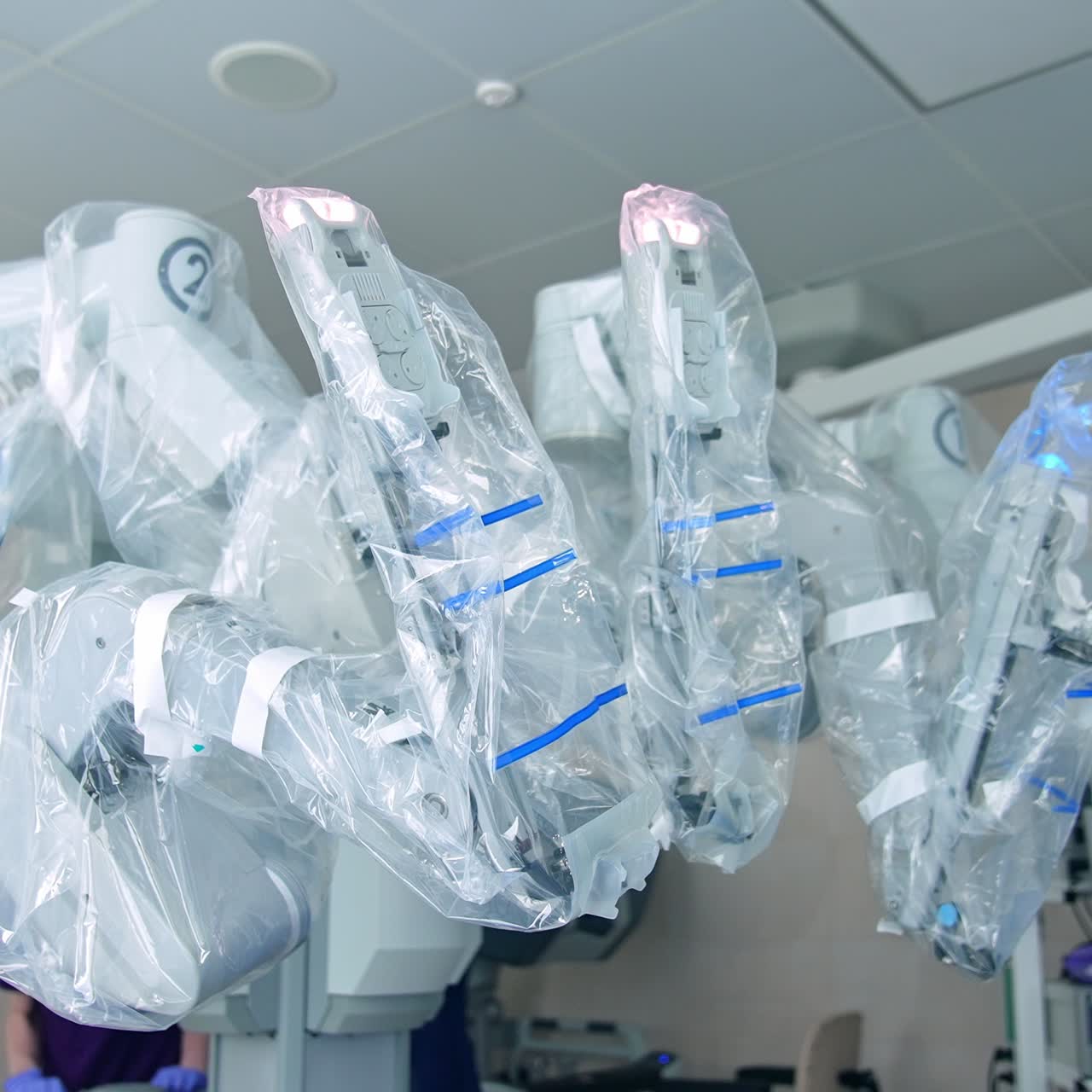 High technological equipment in up-to-date surgical theatre. Medics standing behind the futuristic Da Vinci robot for modern operations
