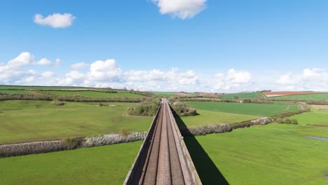 vuelo aéreo de aviones no tripulados hacia adelante siguiendo las vías ferroviarias del viaducto de welland en northamptonshire, también conocido como el viaduto de harringworth y seaton, mostrando el viaduc to más largo de inglaterra