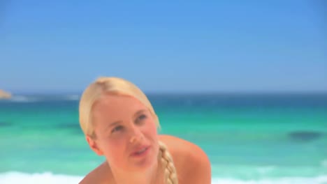 mujer rubia atractiva jugando con una pelota de playa