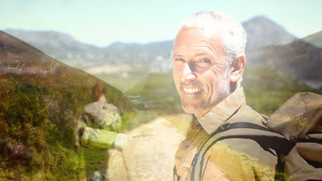 hombre sonriente con mochila caminando por el paisaje panorámico de la montaña