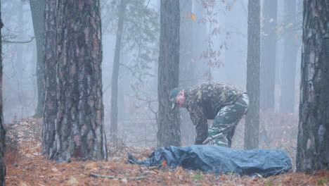 un criminal excava el cuerpo de su víctima en el bosque